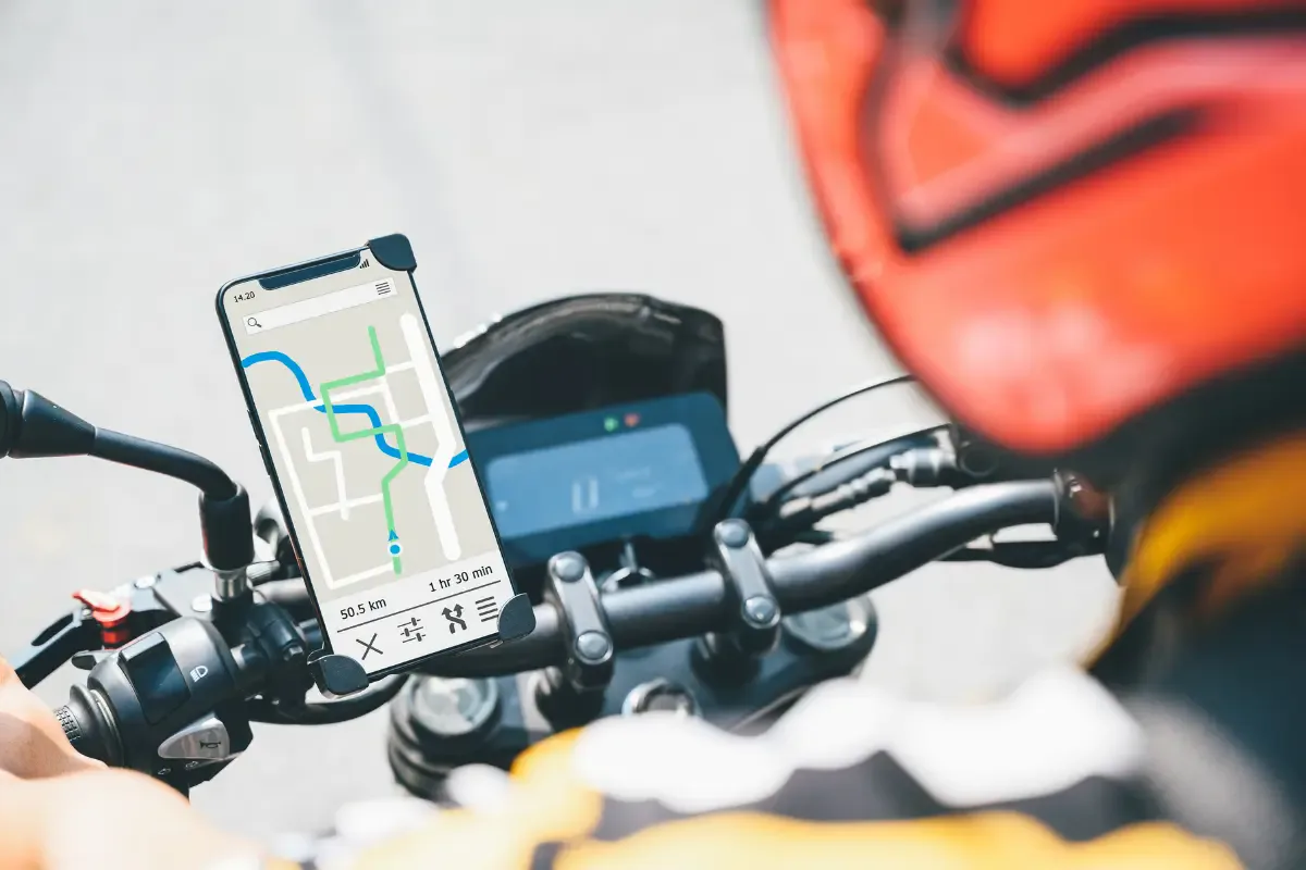 Smartphone montat pe ghidonul unei motociclete, ilustrând riscul de deteriorare a camerei din cauza vibrațiilor.